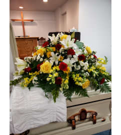 Lily and Sunshine casket Spray. An arrangement by Flowers By Fiore.