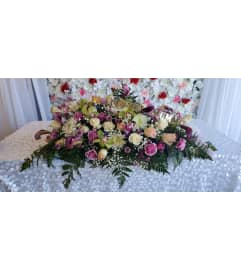 Soft Kisses Casket Spray. An arrangement by Now and Forever Flower Boutique.