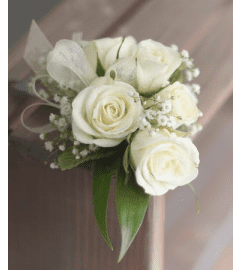 classic white wrist corsage. An arrangement by Plaza Florist and Gifts.