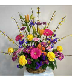 Basket of bright colorful flowers. An arrangement by Flowerville.