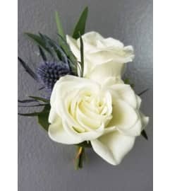 White Mini Rose and Blue Thistle Boutonniere 2022. An arrangement by Northwest Florist.