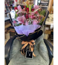Fancy mix bouquet with necklace. An arrangement by Flamingo Floral and Gifts.