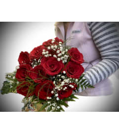 Red Roses handtied with babies breath and greenery. An arrangement by Flowers By Gerry.