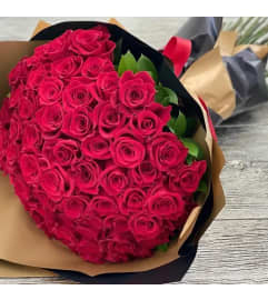 Fifty Long Stem Premium Red Roses With Greens Wrapped. An arrangement by Wasaga Flowers.