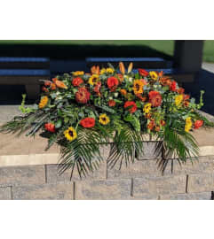 Autumn Sunrise Splendor Casket Spray. An arrangement by Ricky's Flowers and More.
