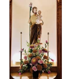 3 SIDED ARRANGEMENT BY JOSEPH STATUE. 31W X 24H 6 POT + grns $. An arrangement by Flowers by Priscilla.
