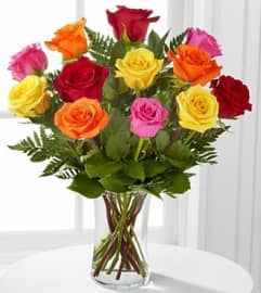 Dozen Rainbow Rose Bouquet. An arrangement by Petals Plus.