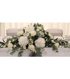 White Bouquet Table Topper. An arrangement by Geni's Florist and Gifts.