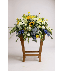 Blue Skies and Sunshine casket spray. An arrangement by Rustic Floral and Gifts.
