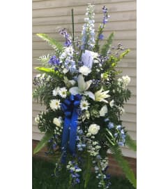 Blue and white tribute spray. An arrangement by Tom's Florist.