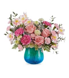 Teleflora's Blue Hues arrangement in blue aqua vase. An arrangement by Nicol Florist.