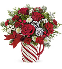 Teleflora's Send a Hug Festive Candy Cane Bouquet. An arrangement by Marivel's Florist and Gifts.