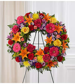 Serene Blessings Bright Standing Wreath. An arrangement by Blessing and Blooms Florist.
