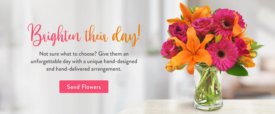 Flower arrangement of orange lilies and pink Gerbera daisies on a table - flower delivery in Garfield