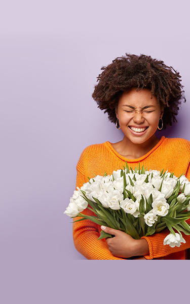 A woman holding flowers and standing next to a man