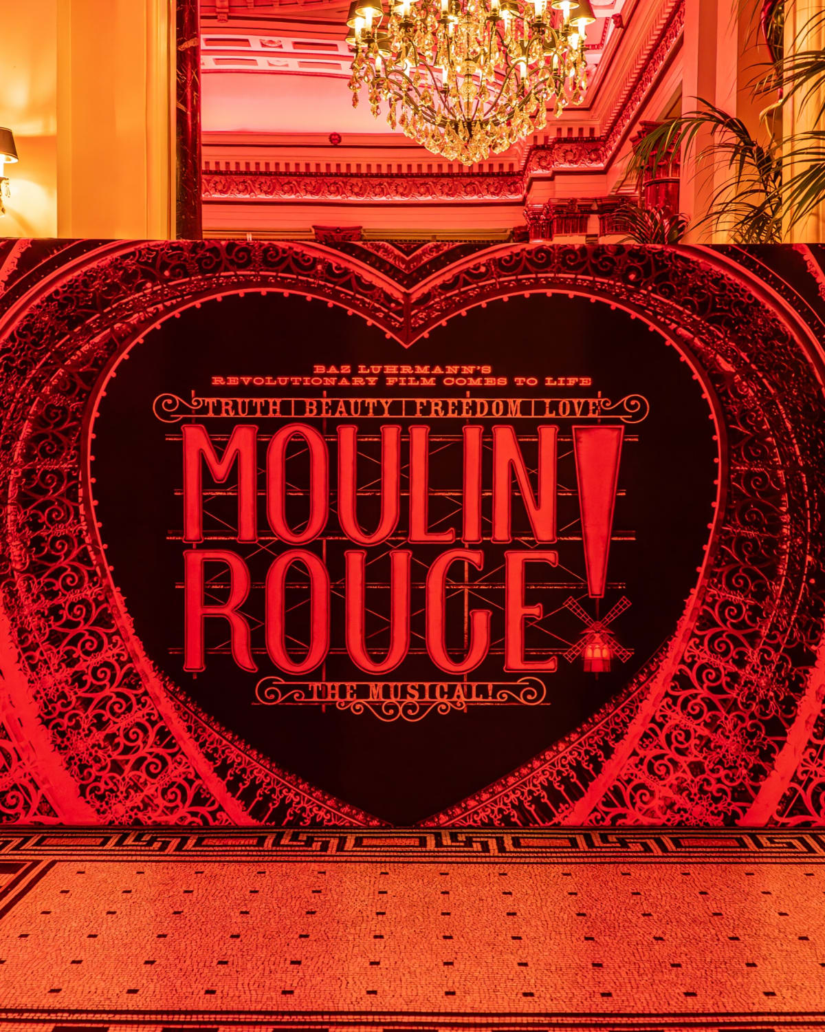 Red lit lounge with orchids inside The Dome during the Moulin Rouge event