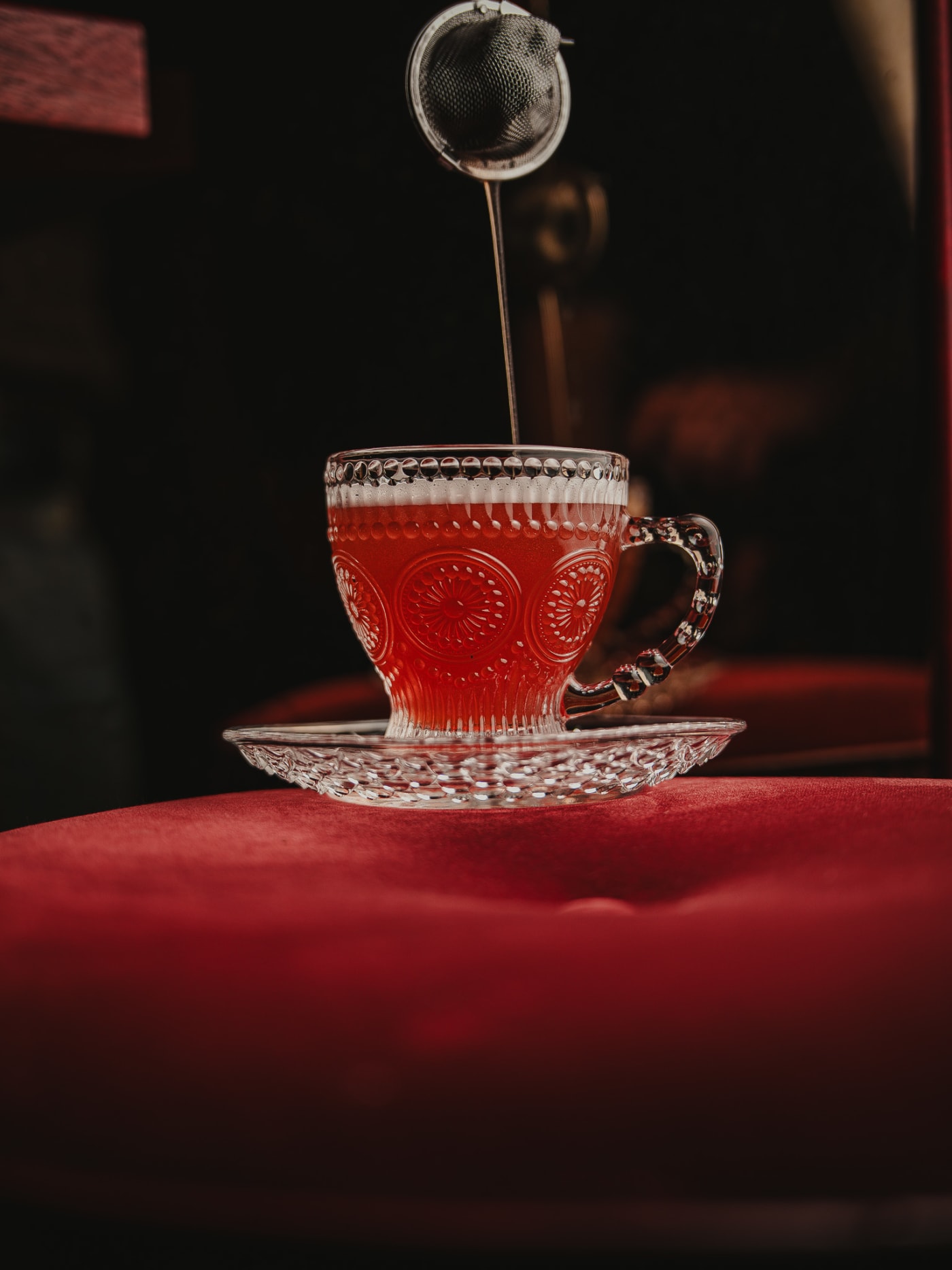 Tea strainer dropped into a glass teacup sour at Jackson The Tailor