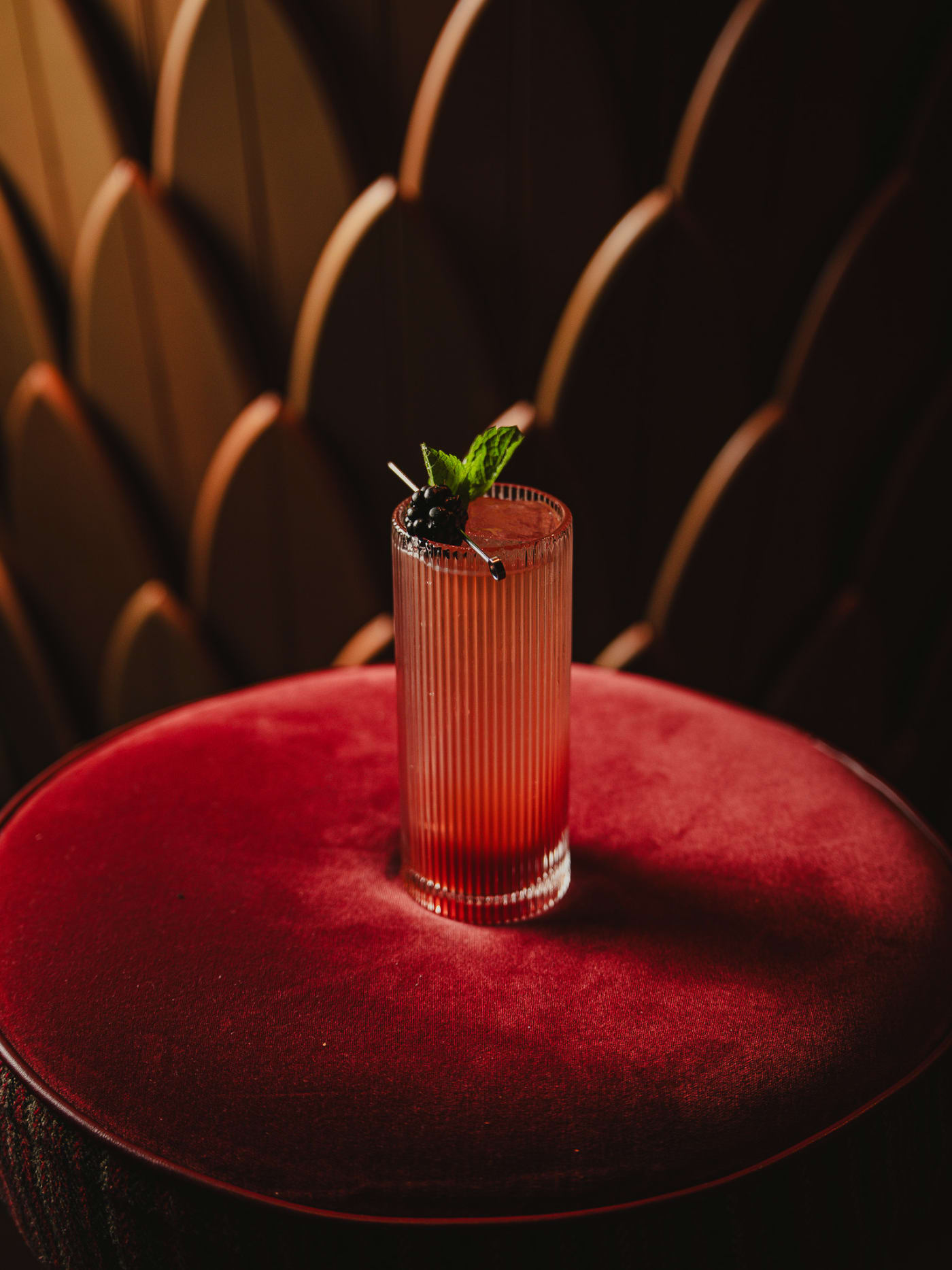 Berry highball on the red velvet stool at Jackson The Tailor
