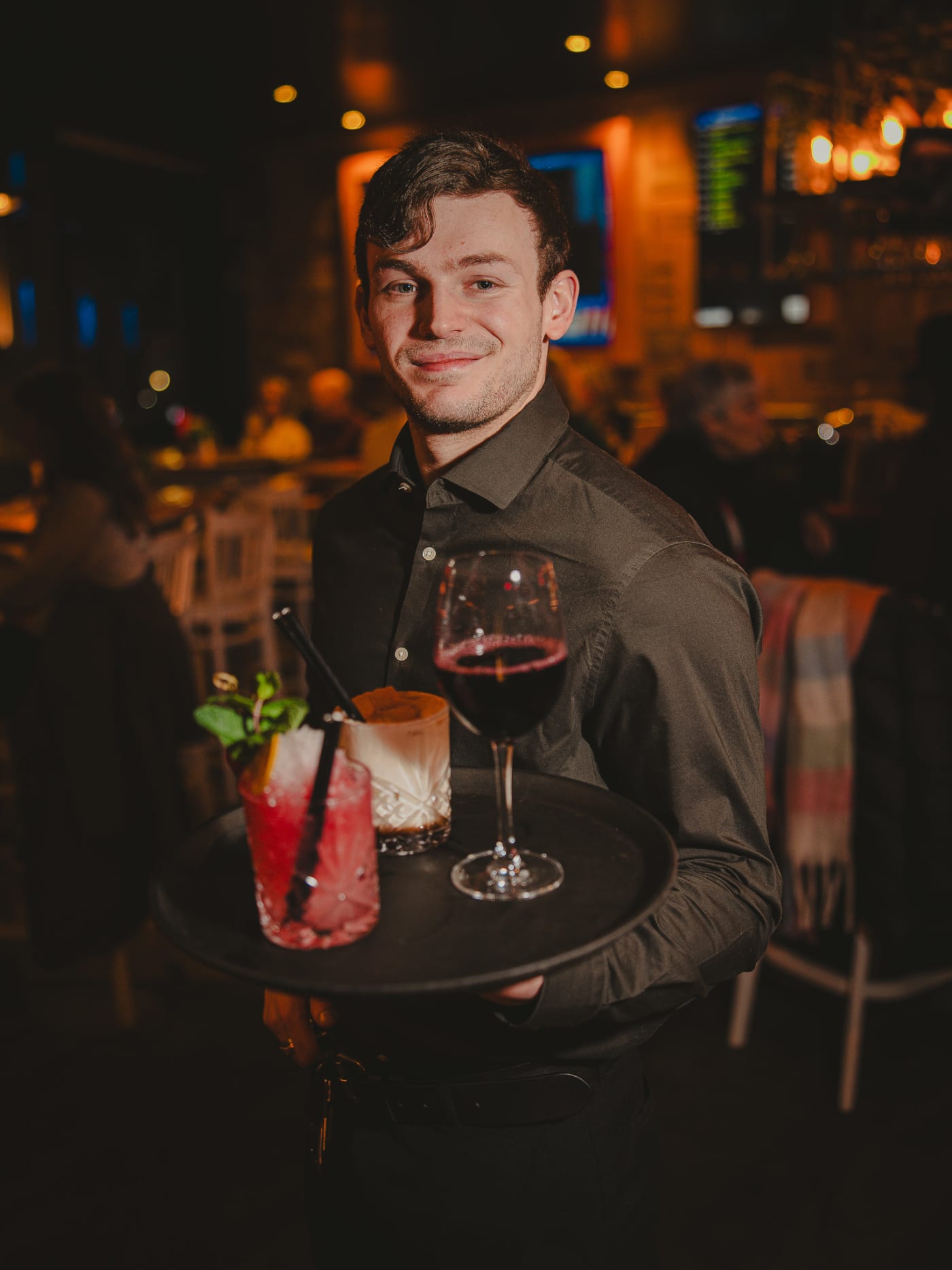 Waiter carrying a tray of cocktails through Newsroom Edinburgh