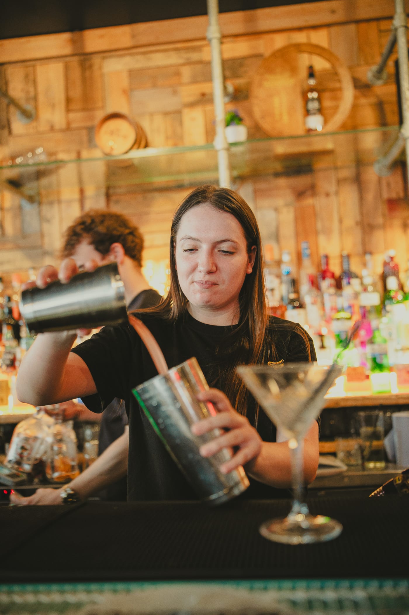 Bartender shaking a cocktail behind the bar at Newsroom