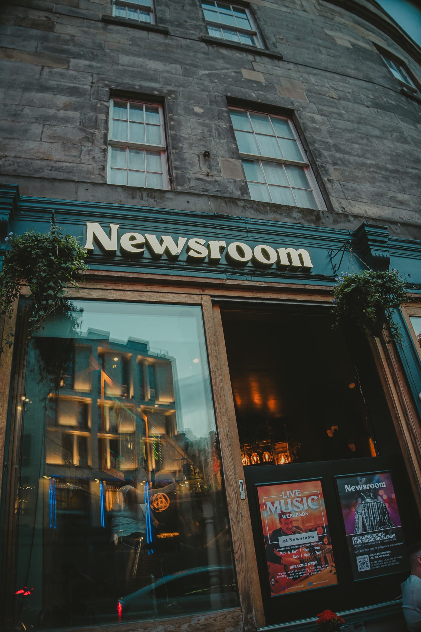 Newsroom sign on the stone facade of the bar and eatery on Leith Street, Edinburgh