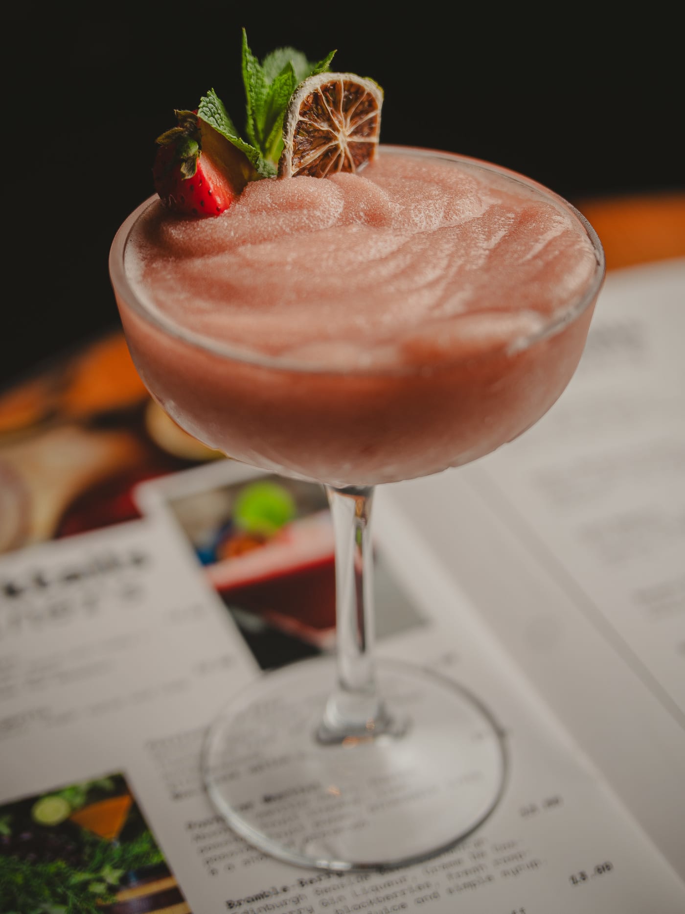 Frozen strawberry cocktail garnished with lime and fresh strawberry served over the menu at Newsroom, Edinburgh