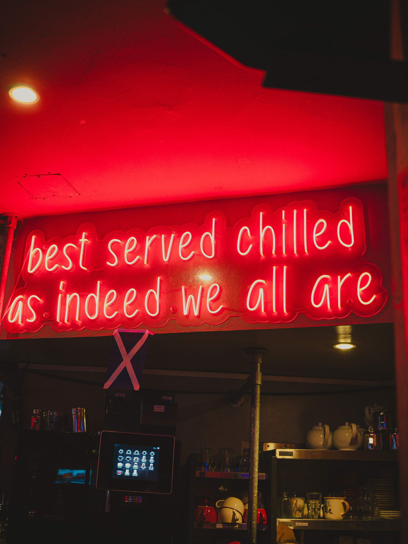 Red neon sign reading best served chilled as indeed we all are at Newsroom, Edinburgh