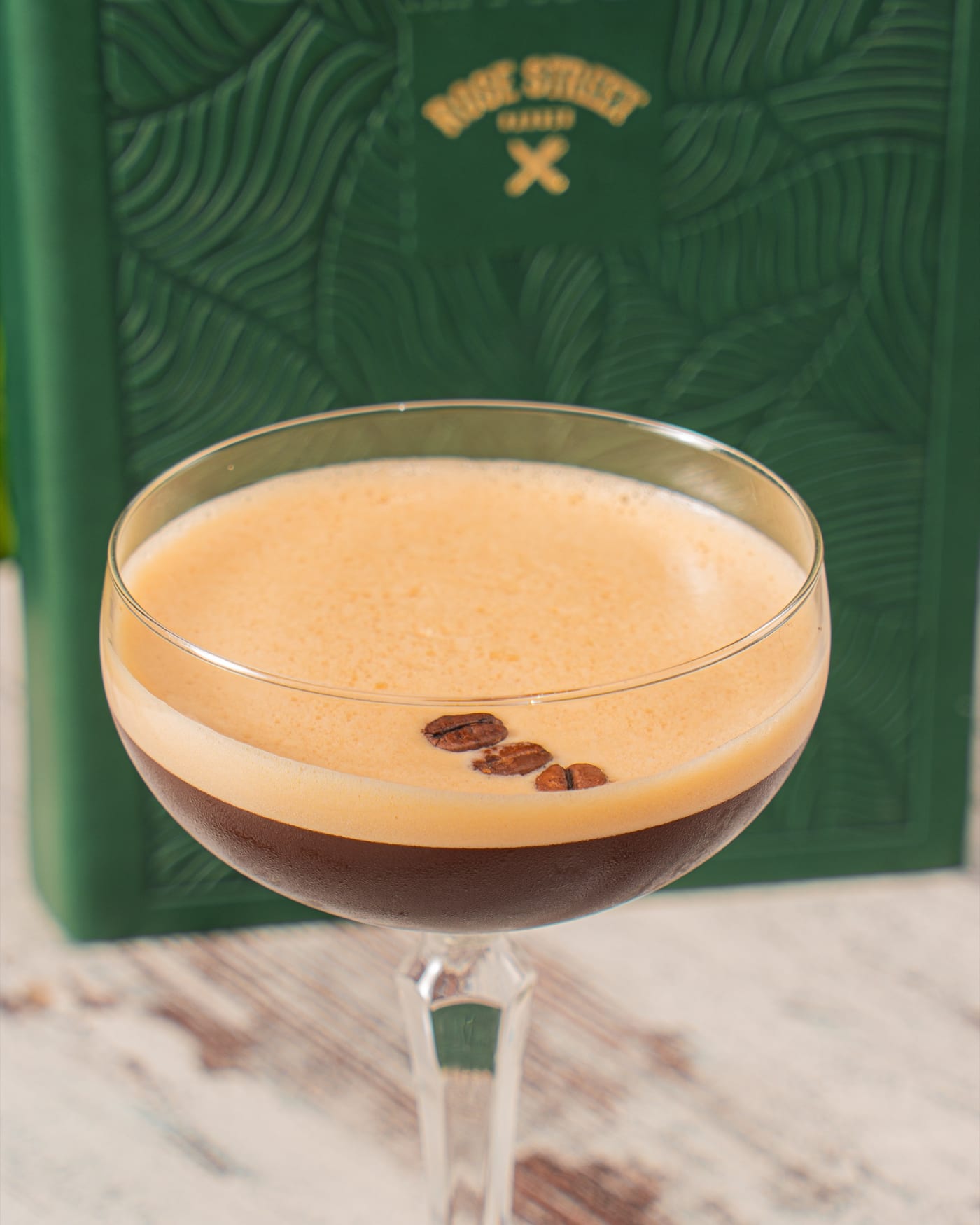 Espresso martini in front of the flower wall at Rose Street Garden, Edinburgh