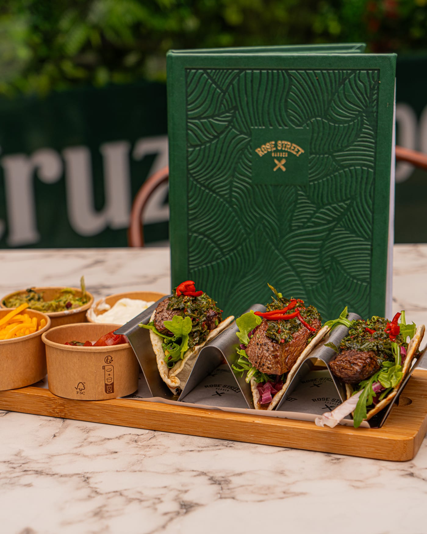 Steak tacos on a serving stand beside the menu at Rose Street Garden, Edinburgh