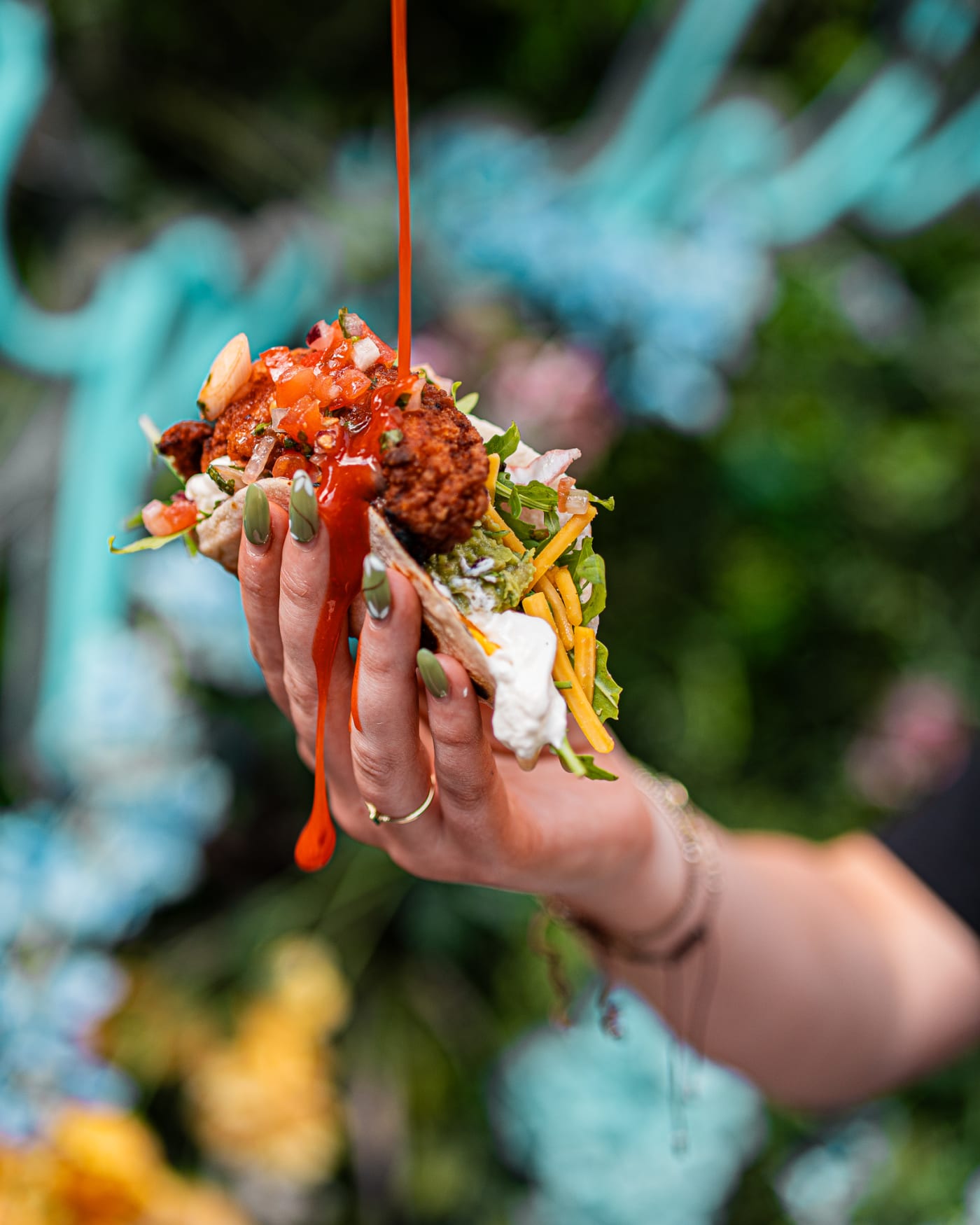 Loaded taco held up under the neon sign at Rose Street Garden, Edinburgh