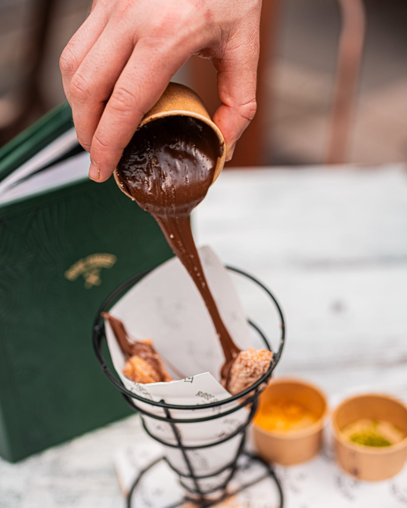 Chocolate sauce poured over fresh churros at Rose Street Garden, Edinburgh