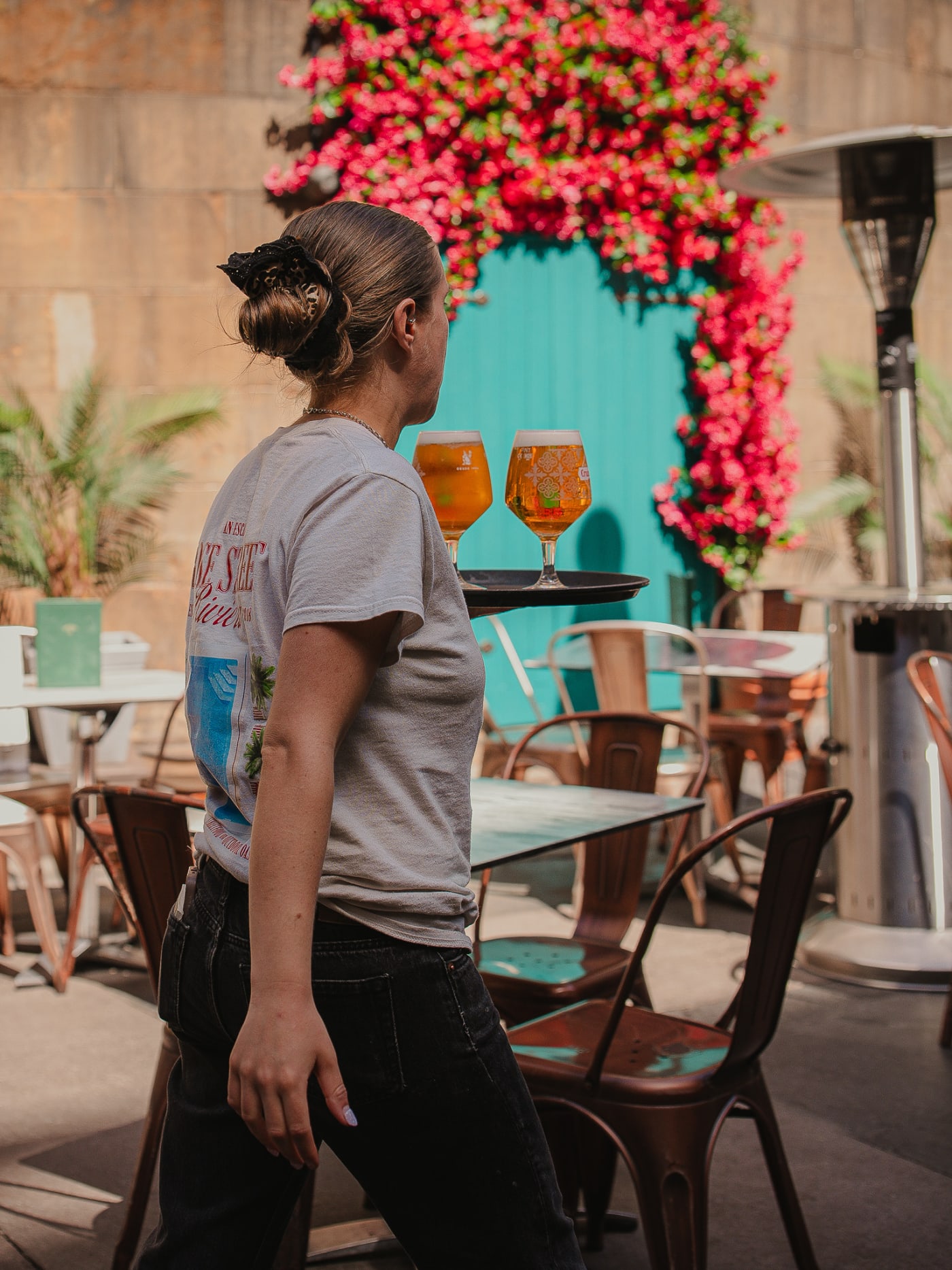 Server crossing the terrace with spritzes at Rose Street Garden, Edinburgh