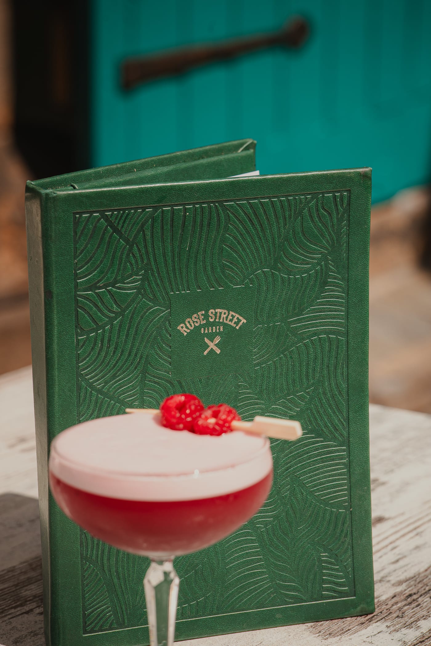 Raspberry sour beside the leaf-embossed menu at Rose Street Garden, Edinburgh