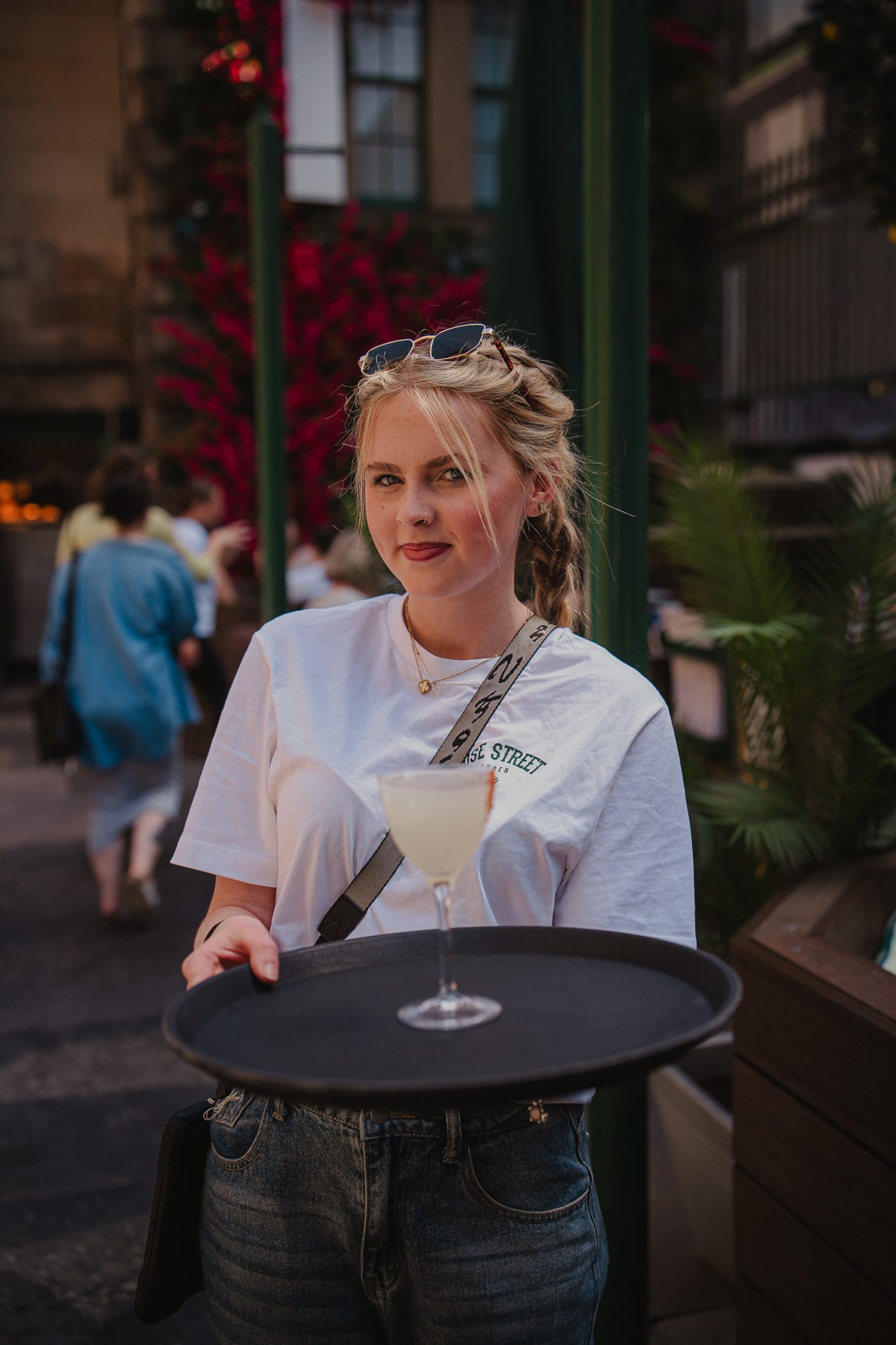 Waitress carrying a margarita on her tray at Rose Street Garden, Edinburgh