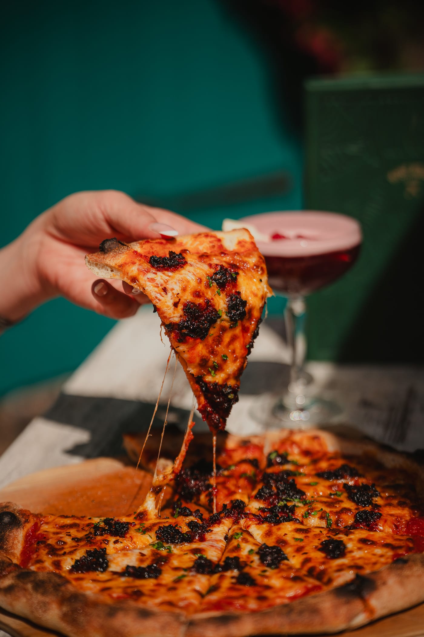 Lifting a slice of wood-fired pizza at Rose Street Garden, Edinburgh