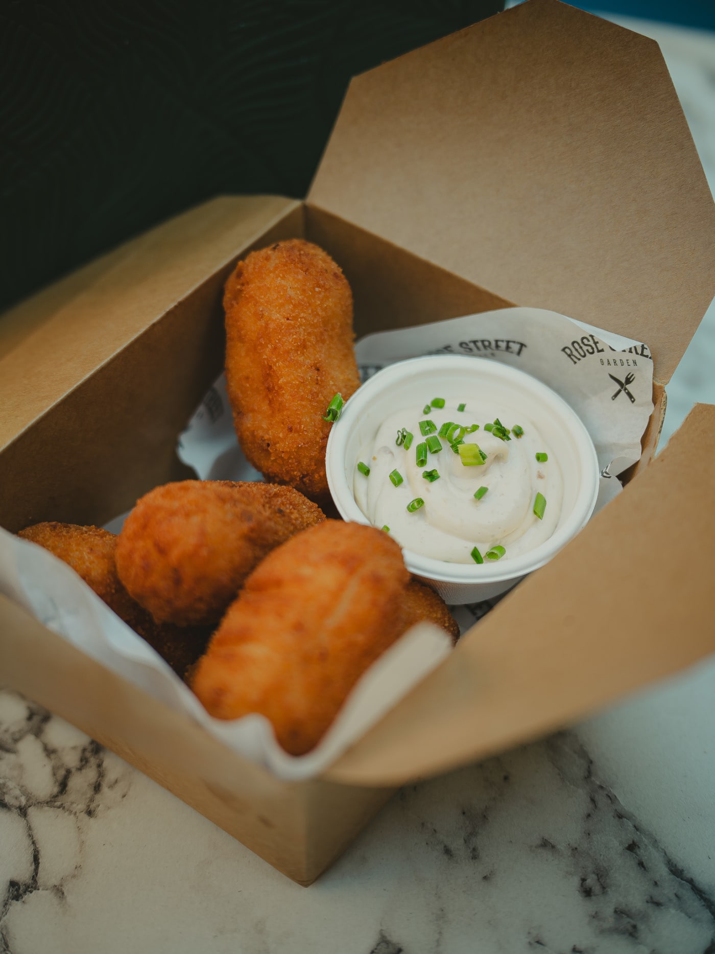 Croquettes with dip in a takeaway box at Rose Street Garden, Edinburgh