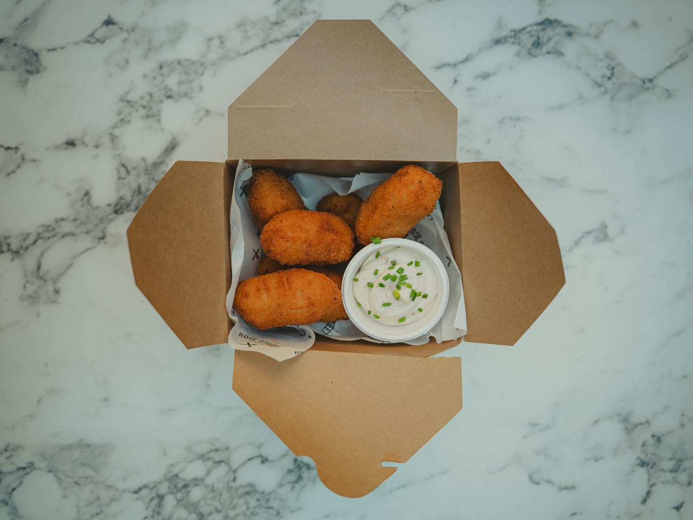 Croquettes box from above on marble at Rose Street Garden, Edinburgh