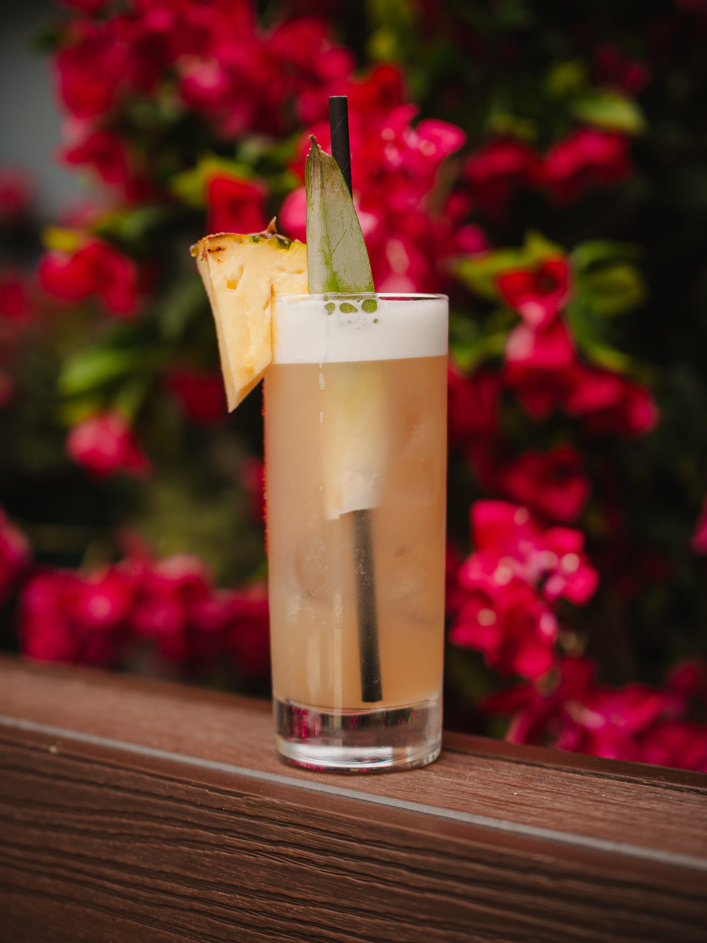 Tall spritz with pineapple against the flowers at Rose Street Garden, Edinburgh