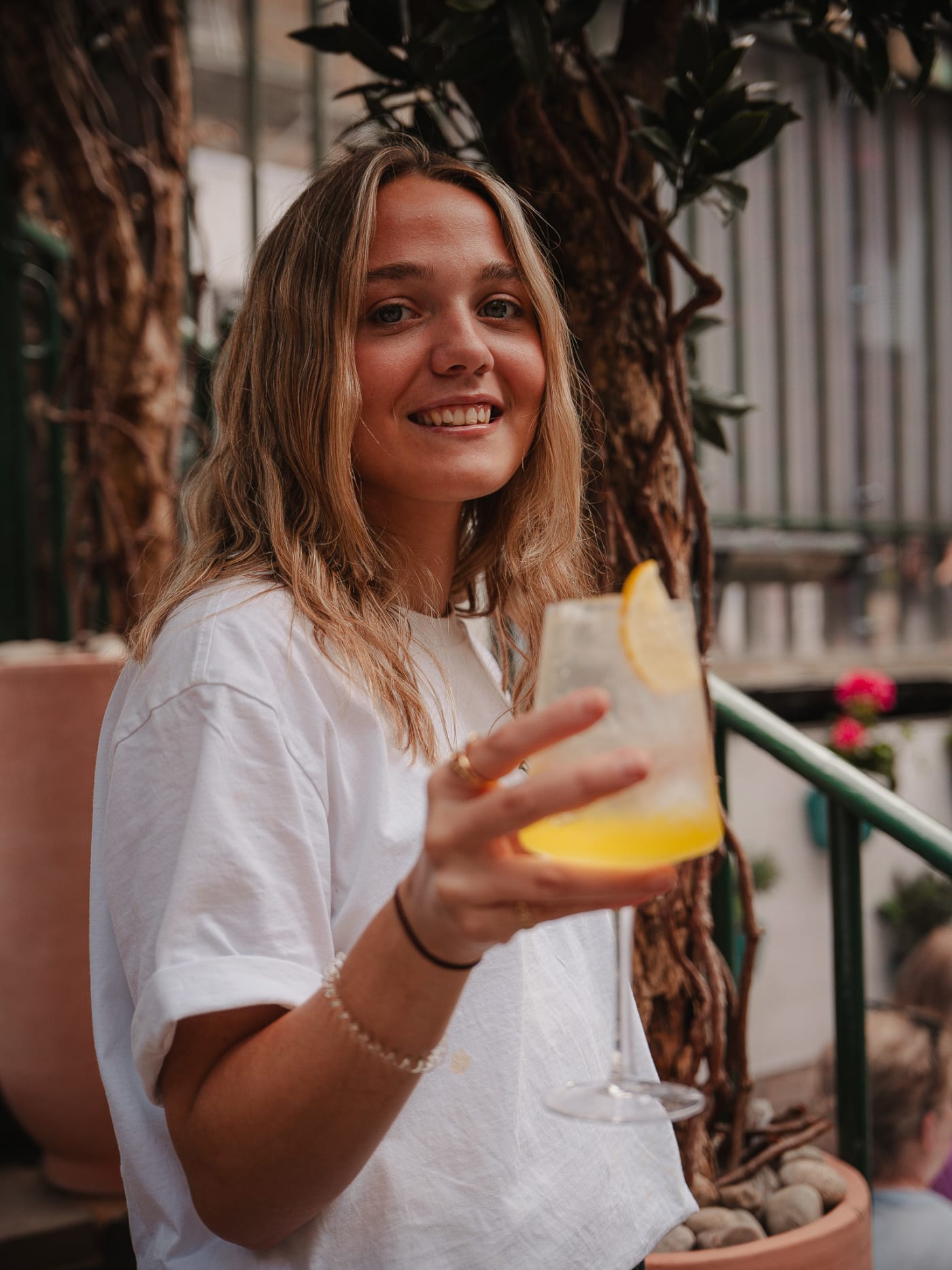 Guest smiling with an orange spritz under the lemon tree at Rose Street Garden, Edinburgh