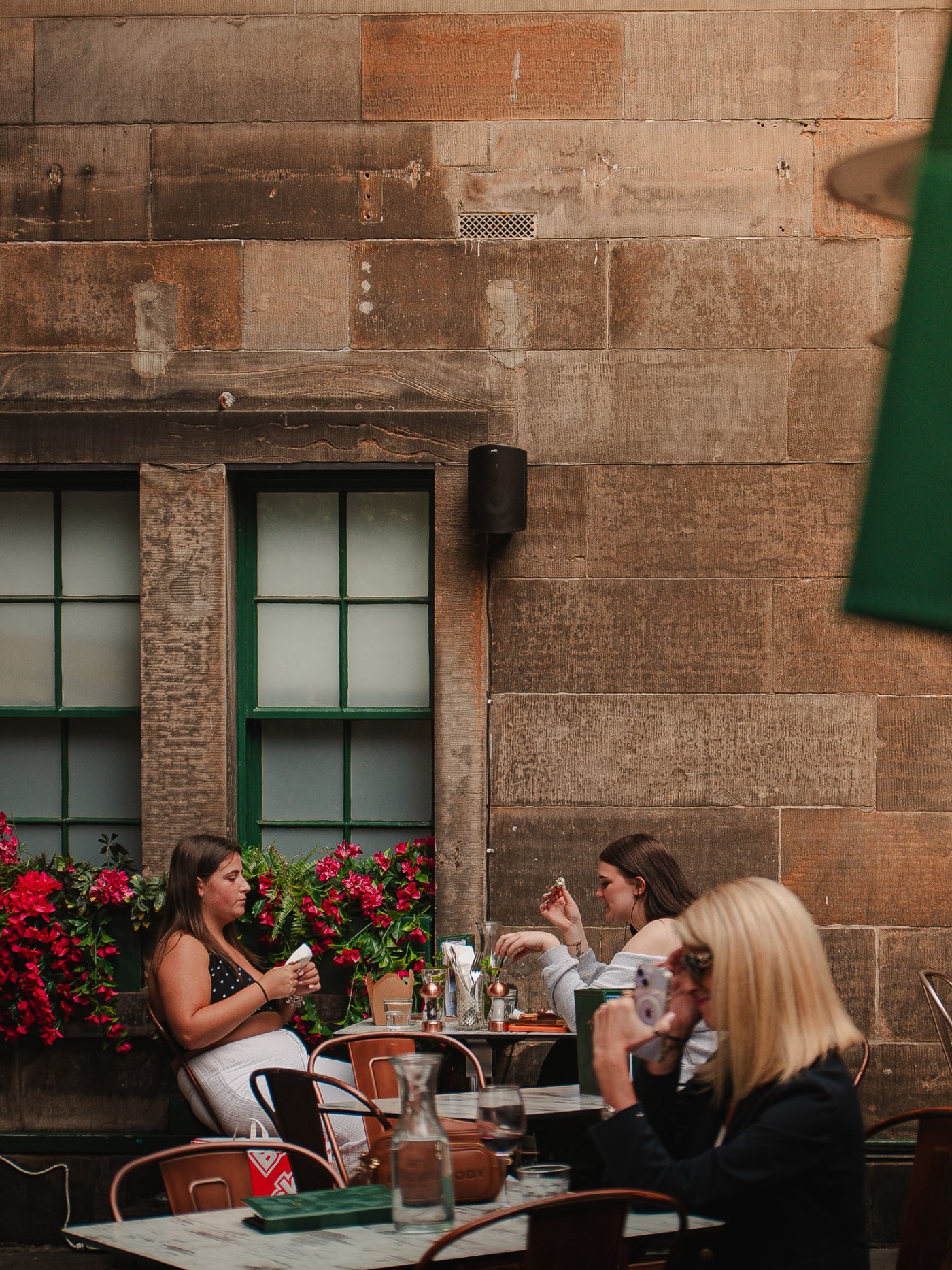 Tables of guests beneath the flower-covered windows at Rose Street Garden, Edinburgh