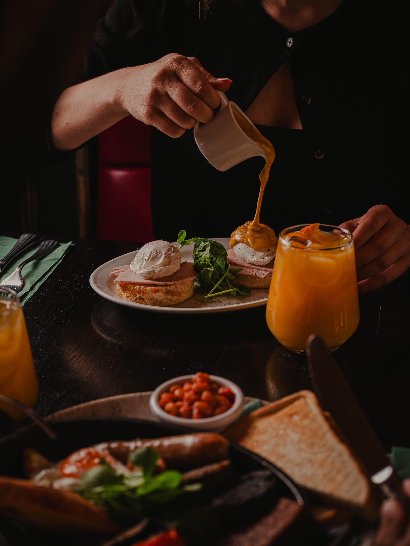 Hollandaise poured over eggs Benedict with fresh orange juice at Ryan’s of Edinburgh