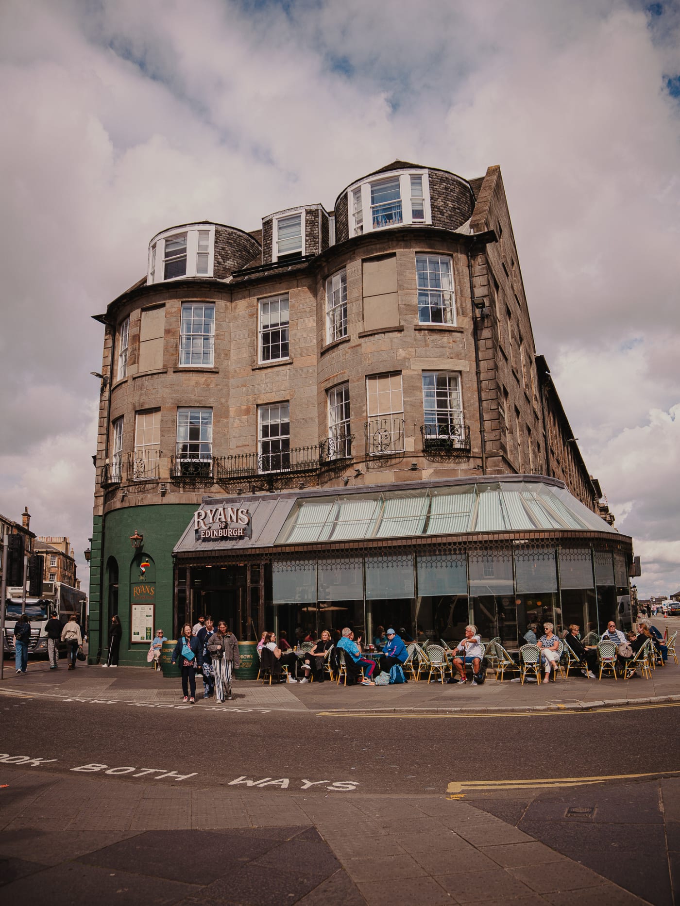 Ryan’s of Edinburgh on its West End corner under summer clouds