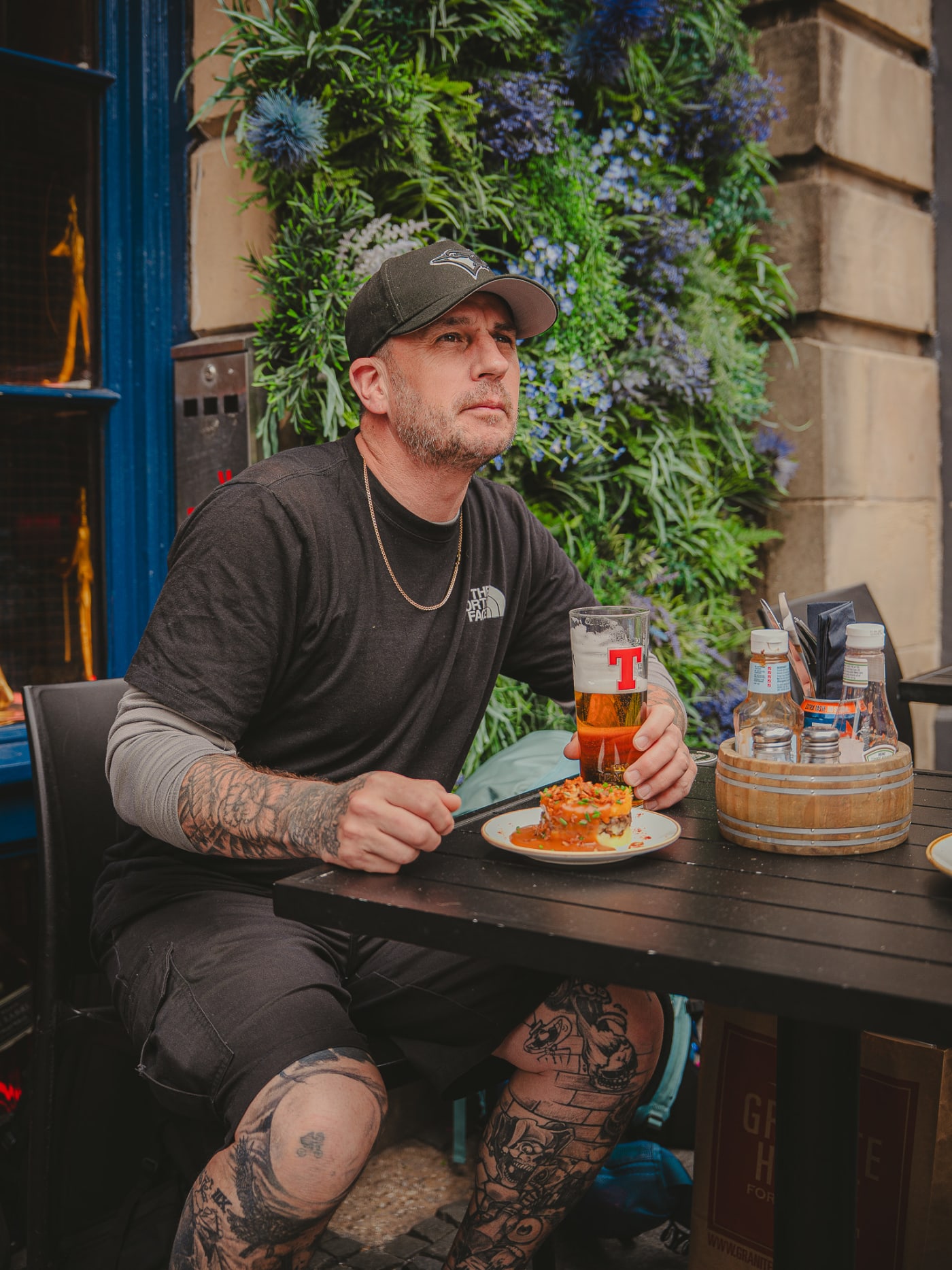 Guest with food and a pint on the terrace at The Piper's Rest