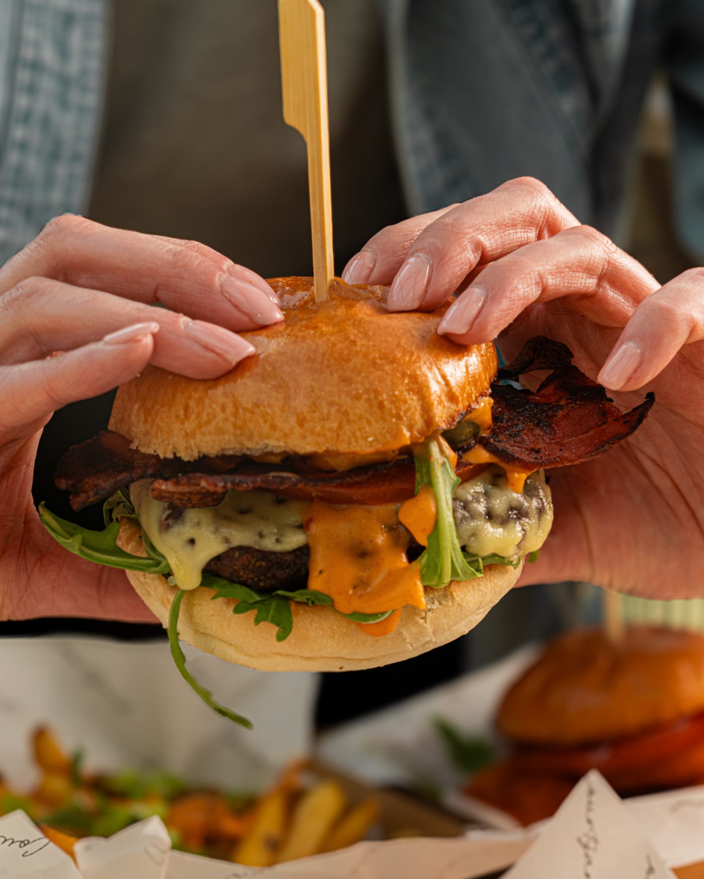 Hand holding a burger at The Ship Inn, Musselburgh