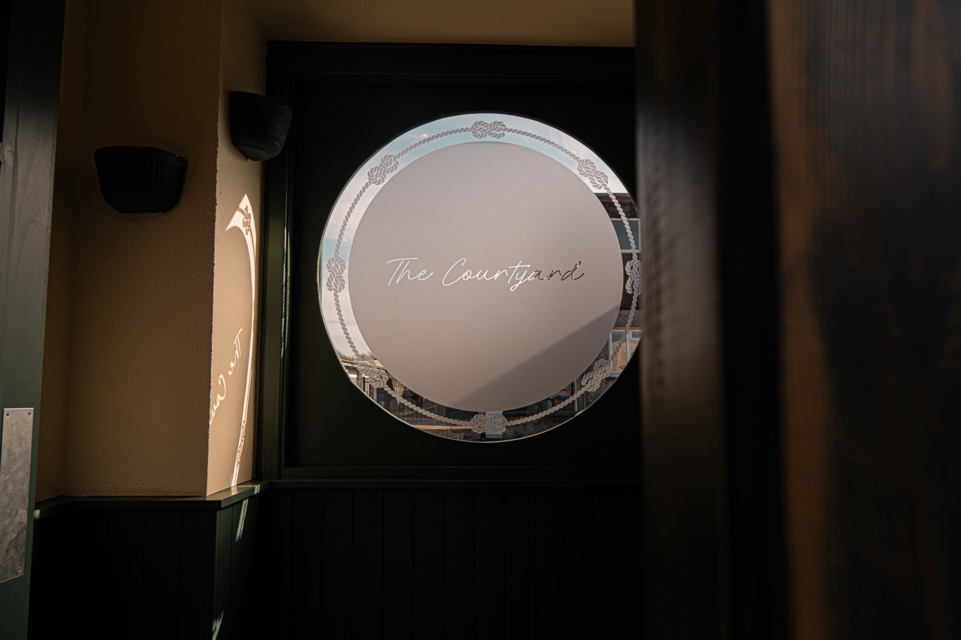 The Courtyard sign lit at night at The Ship Inn