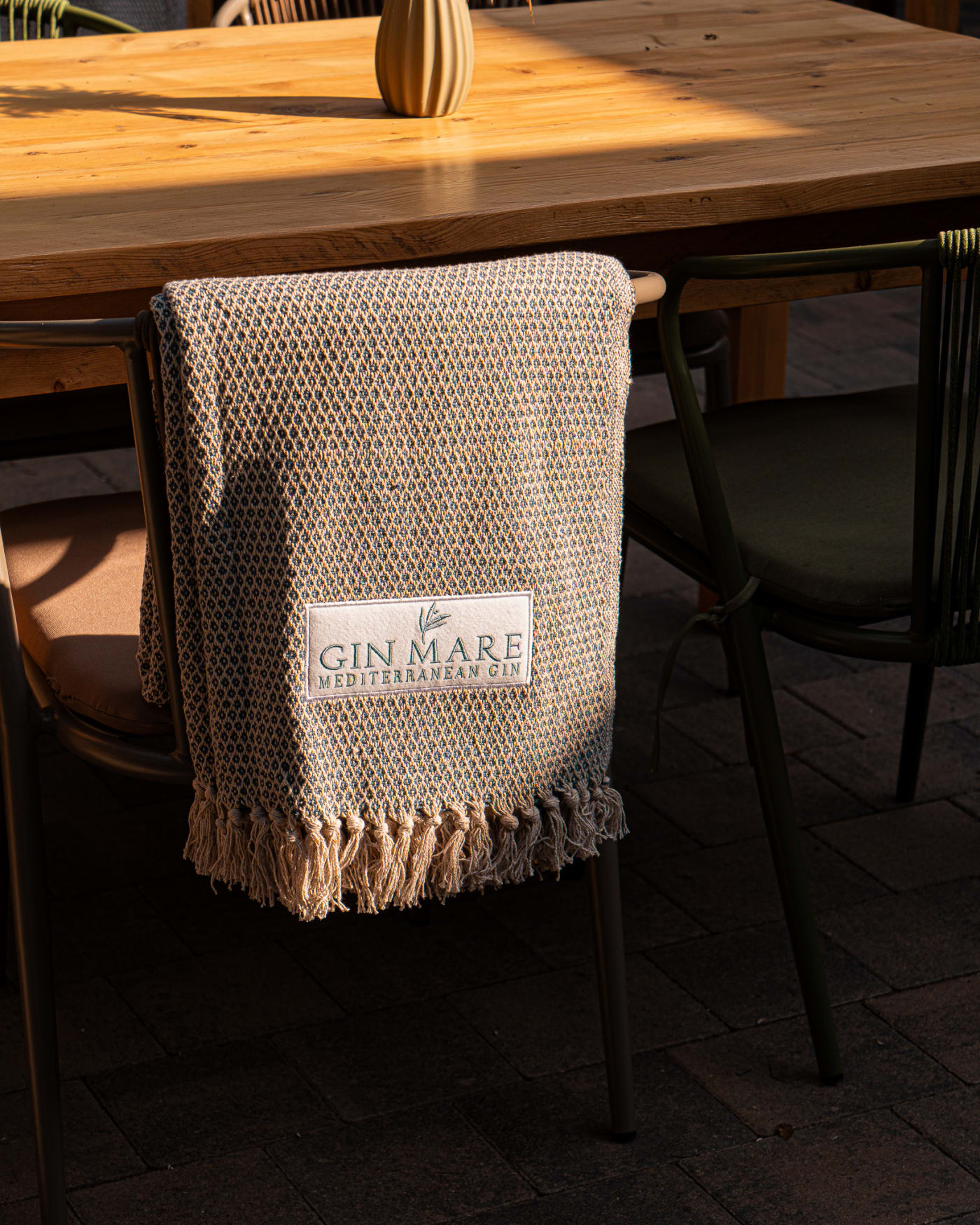 Gin Mare branded towel on a chair in The Courtyard at The Ship Inn