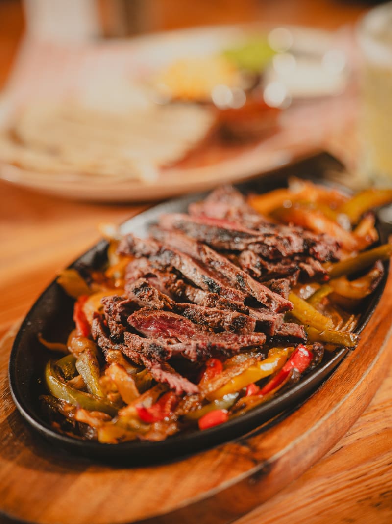 Steak fajitas with tortillas and dips at Newsroom