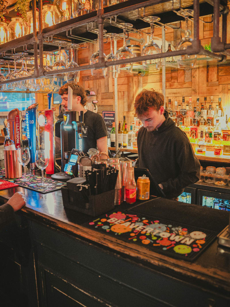 Bartenders at work behind the bar at Newsroom