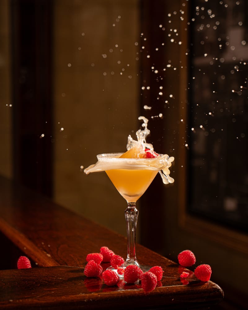 Cream poured over an orange cocktail at Tiles Bar