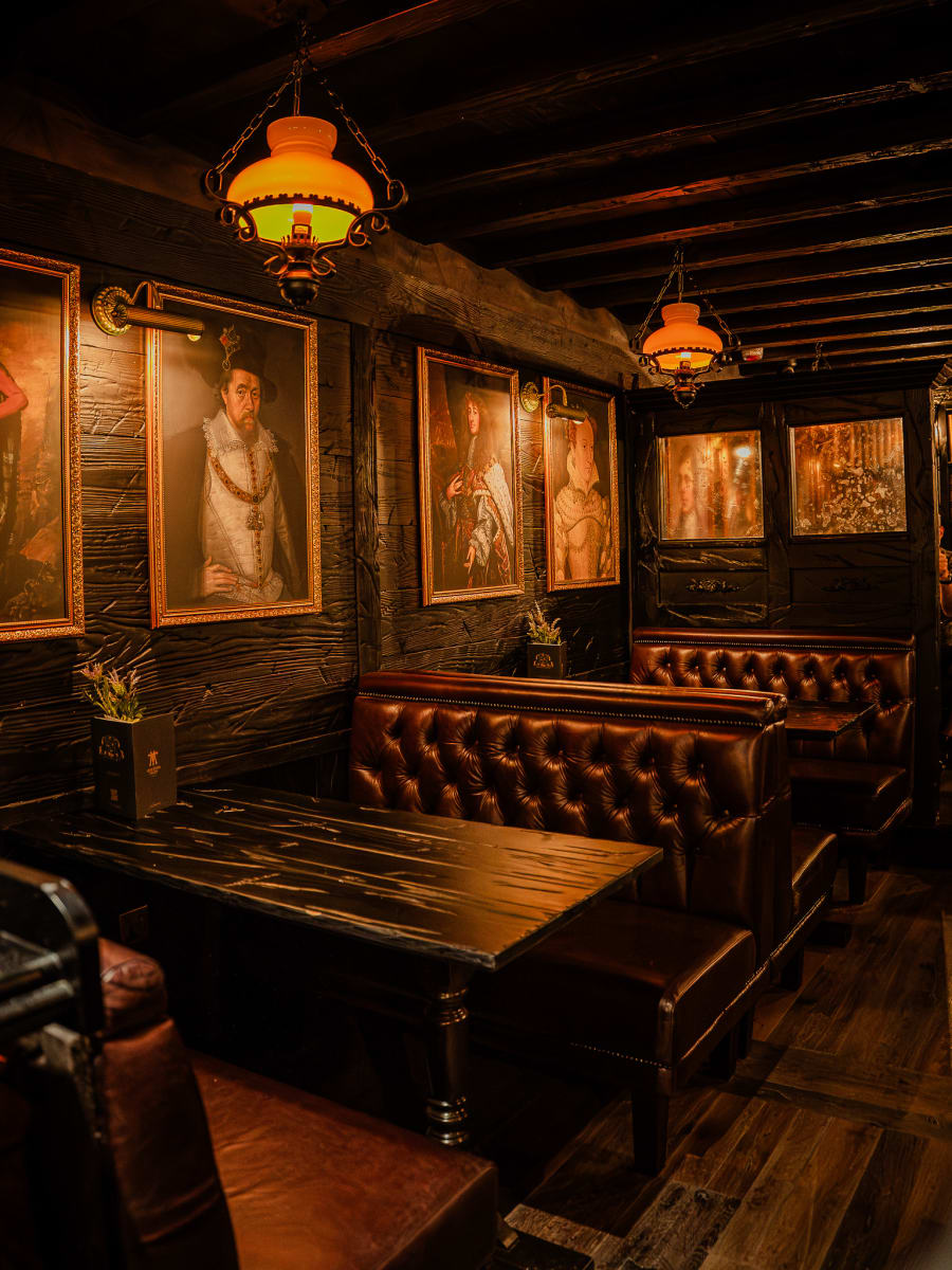 Chesterfield leather snug beneath oil portraits and lamplight at Merchant Tavern, Edinburgh